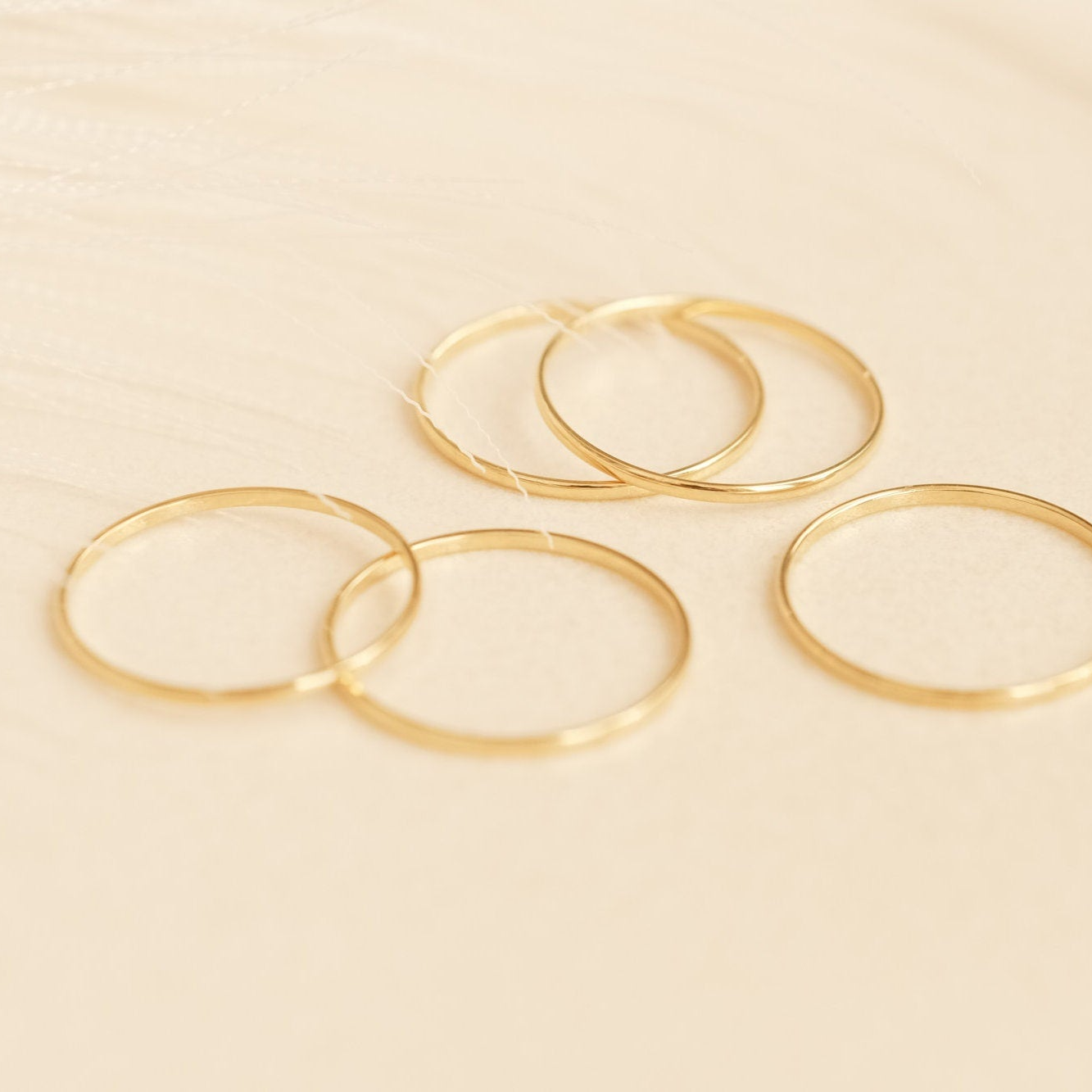 a set of four gold filled rings on a white surface