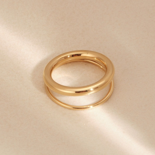 two gold rings sitting on top of a table