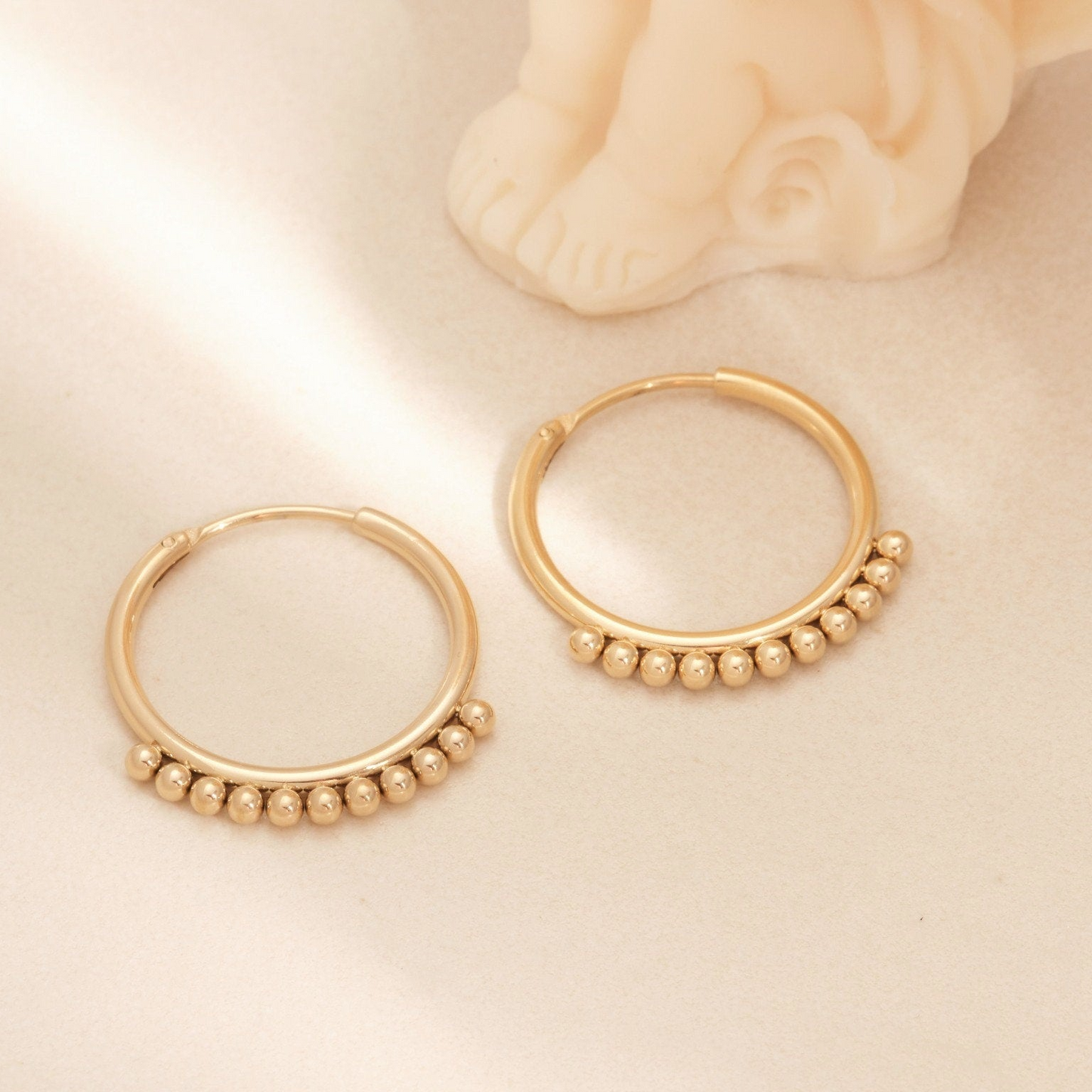 a close up of a pair of gold hoop earrings