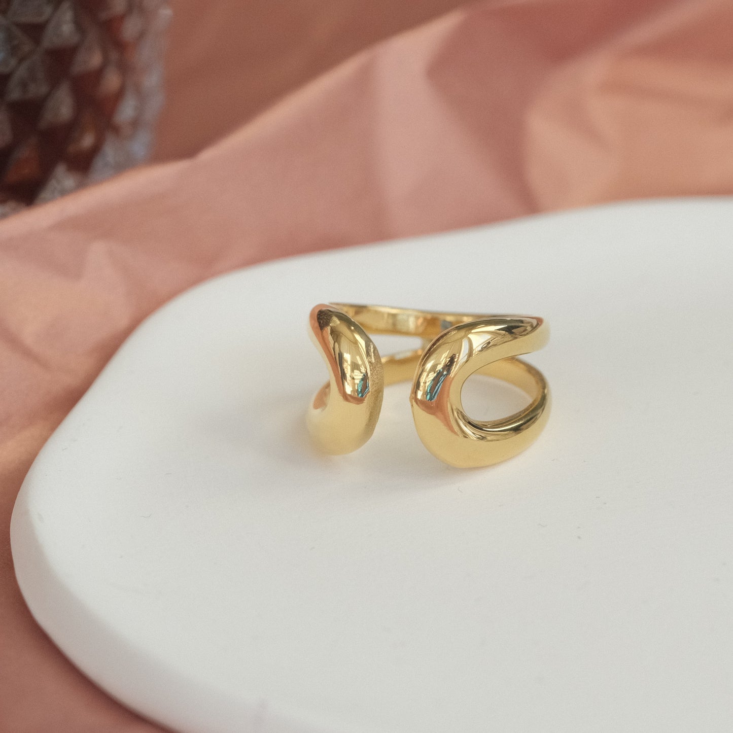 a gold ring sitting on top of a white plate