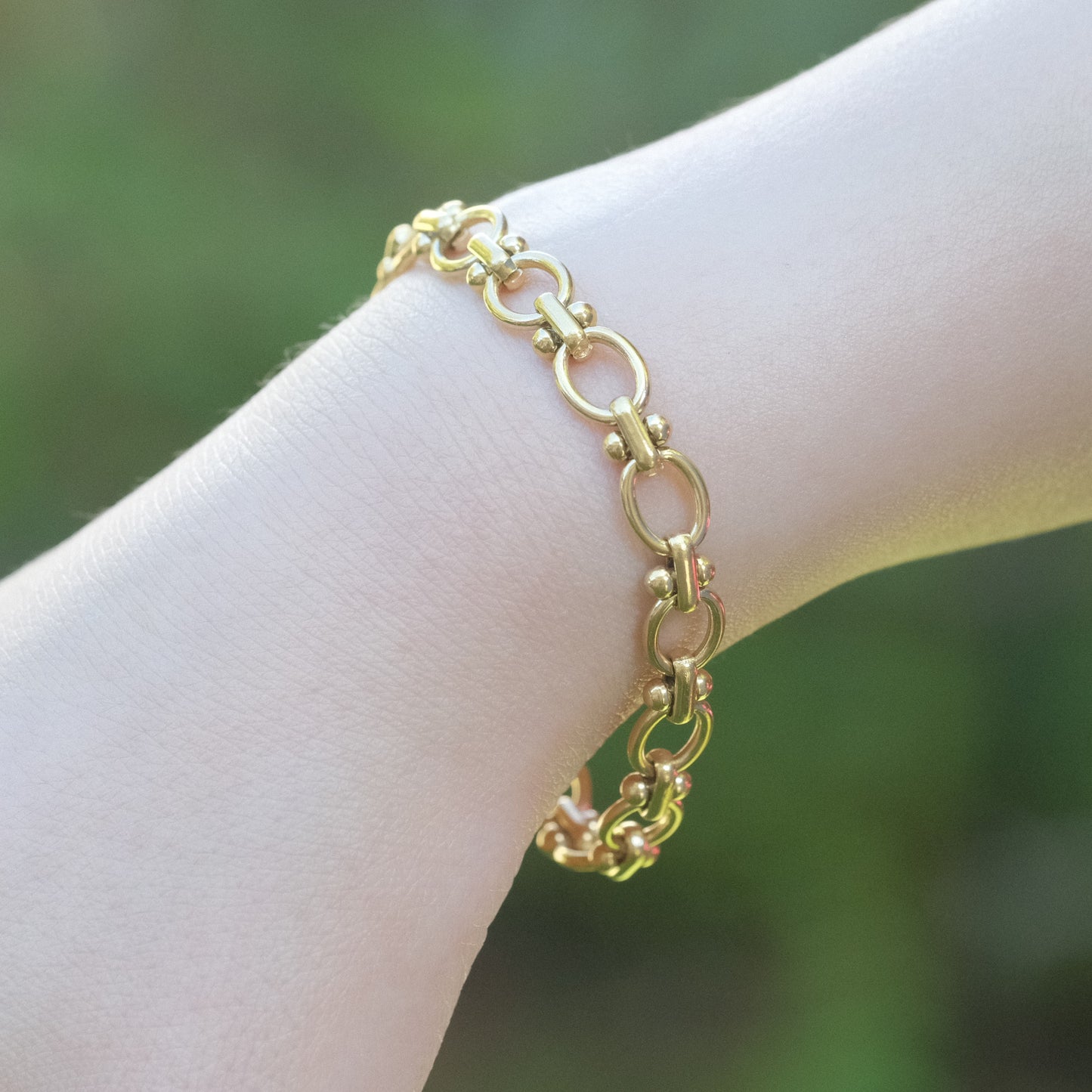 a person wearing a gold chain bracelet