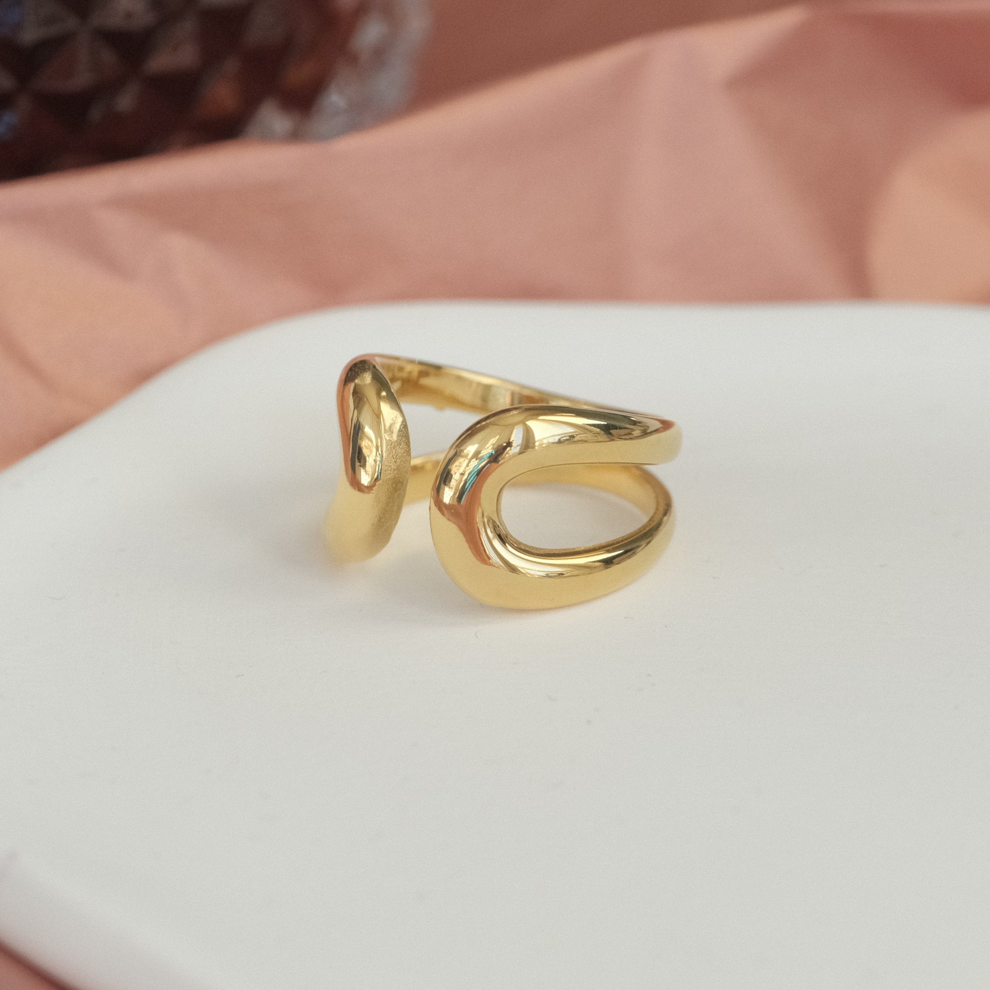 a gold ring sitting on top of a white plate