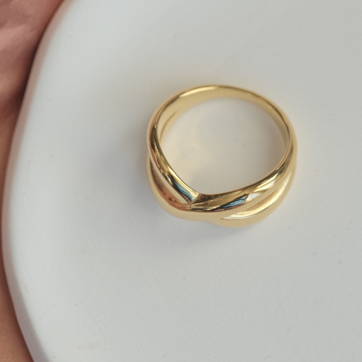 a gold ring sitting on top of a white plate