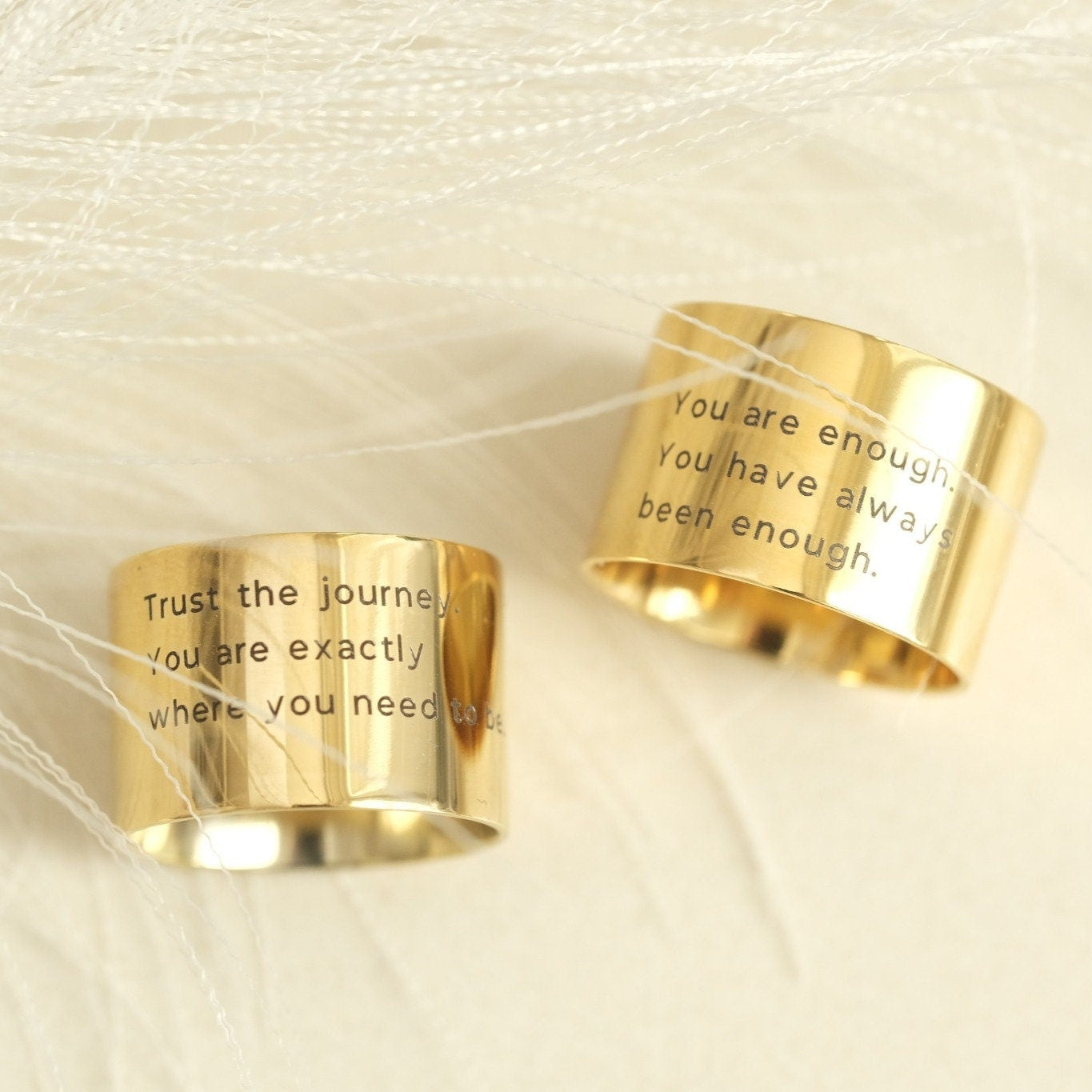 two gold rings with words written on them