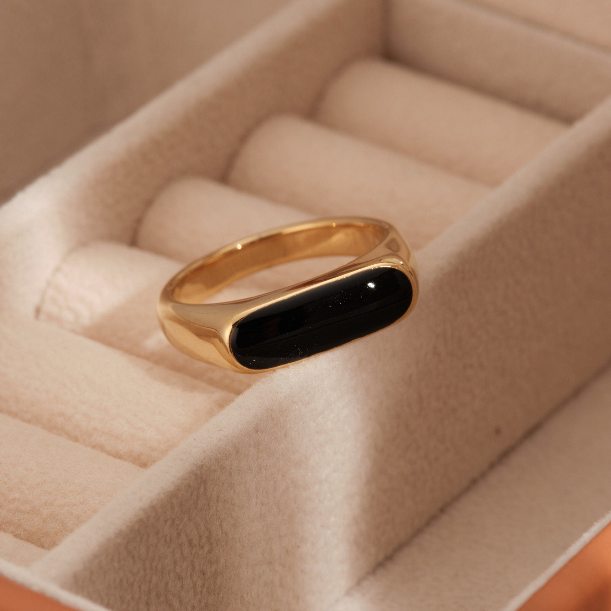 a gold ring with a black stone in it