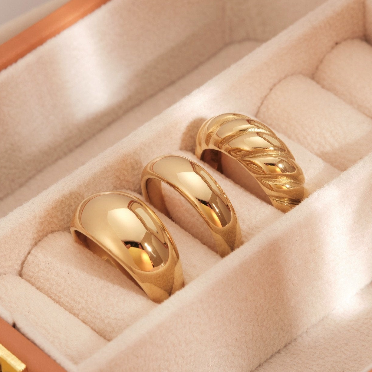 a couple of gold rings sitting inside of a box