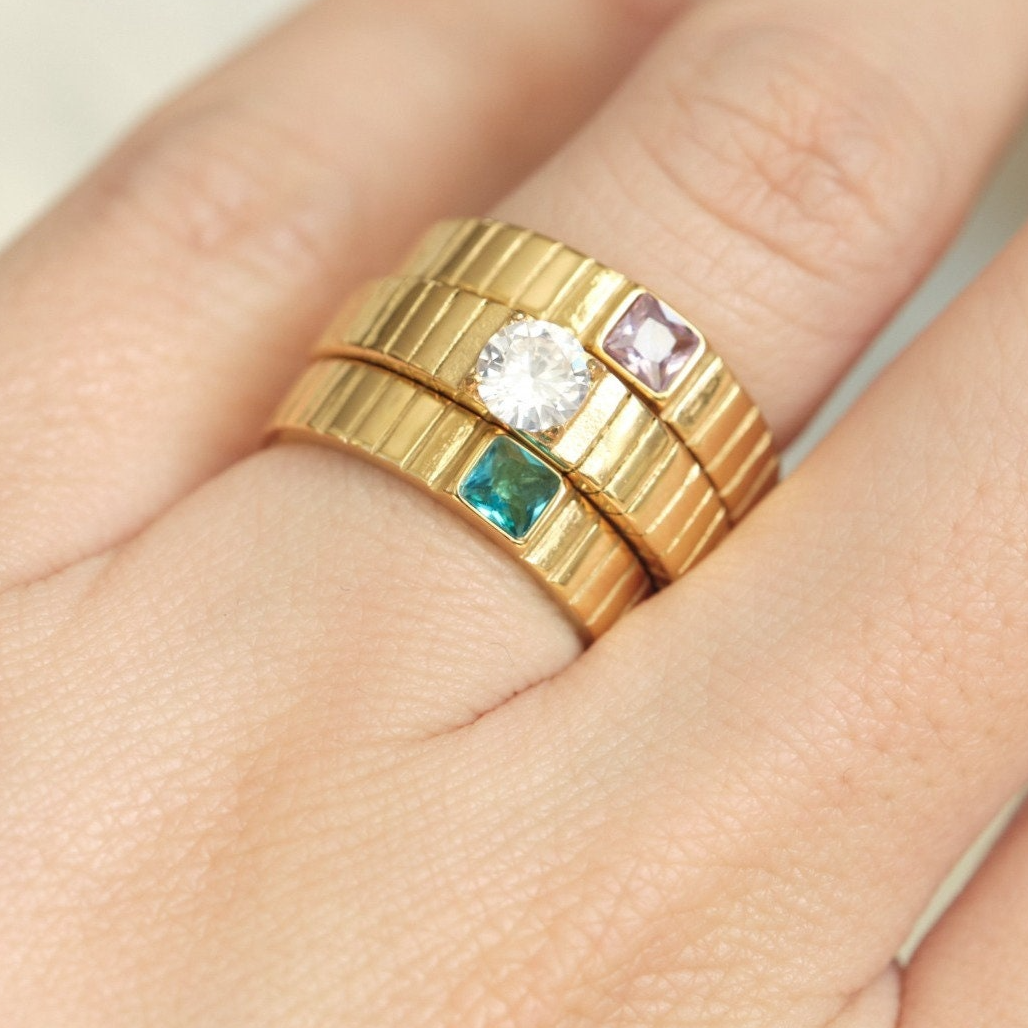 a close up of a person's hand with two rings