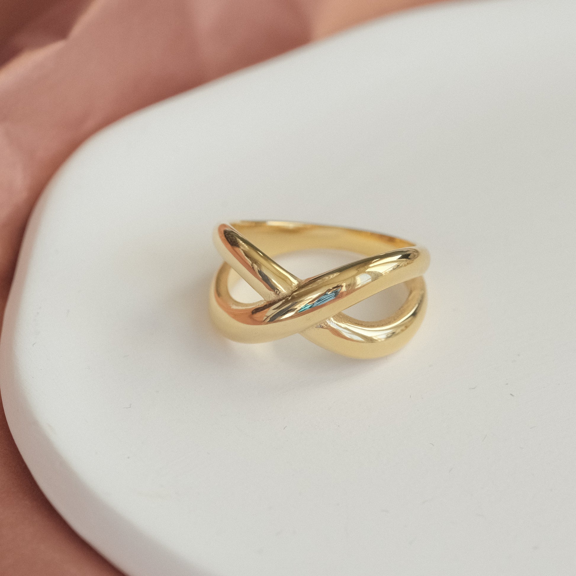 a gold ring sitting on top of a white plate