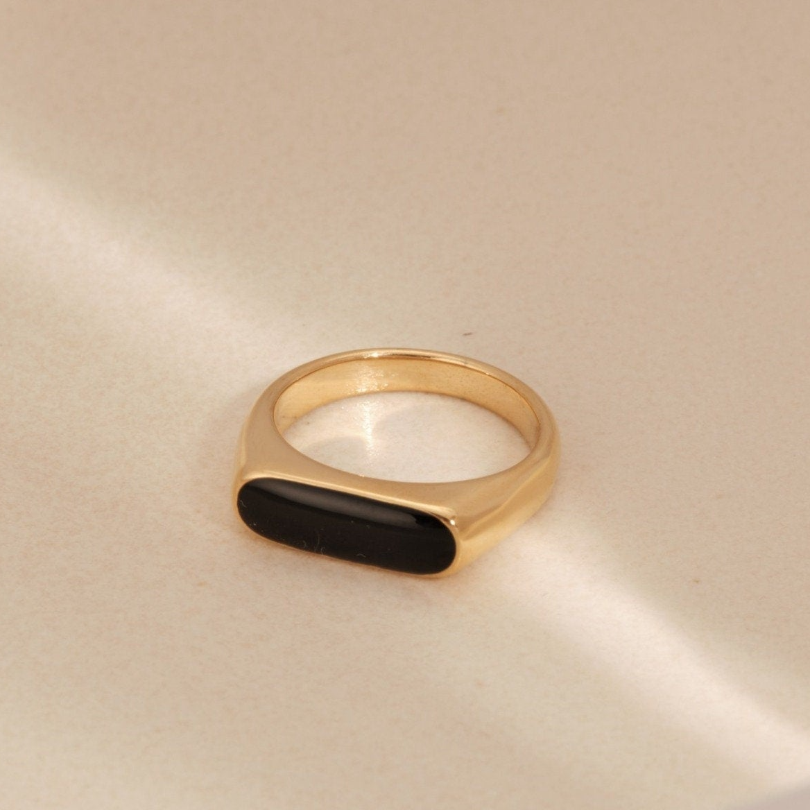 a gold ring with a black stone on it