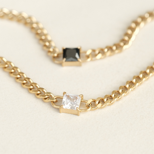 a gold chain with a square cut diamond on it