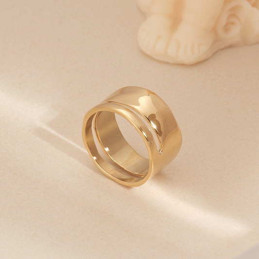 a pair of gold rings sitting on top of a table