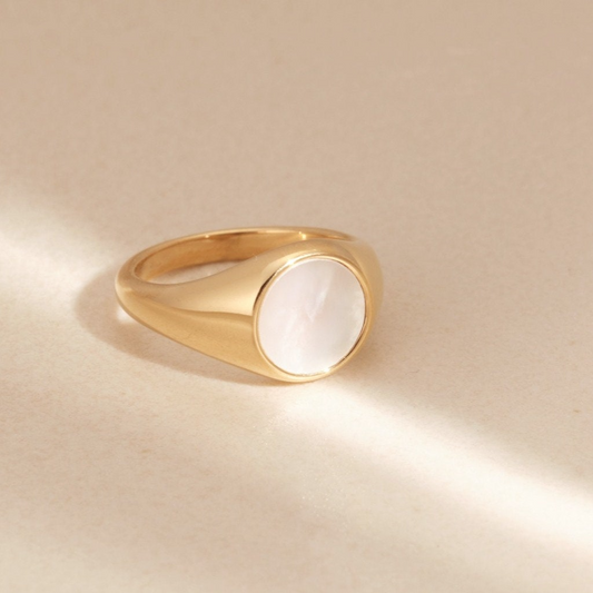 a gold ring with a white stone on it