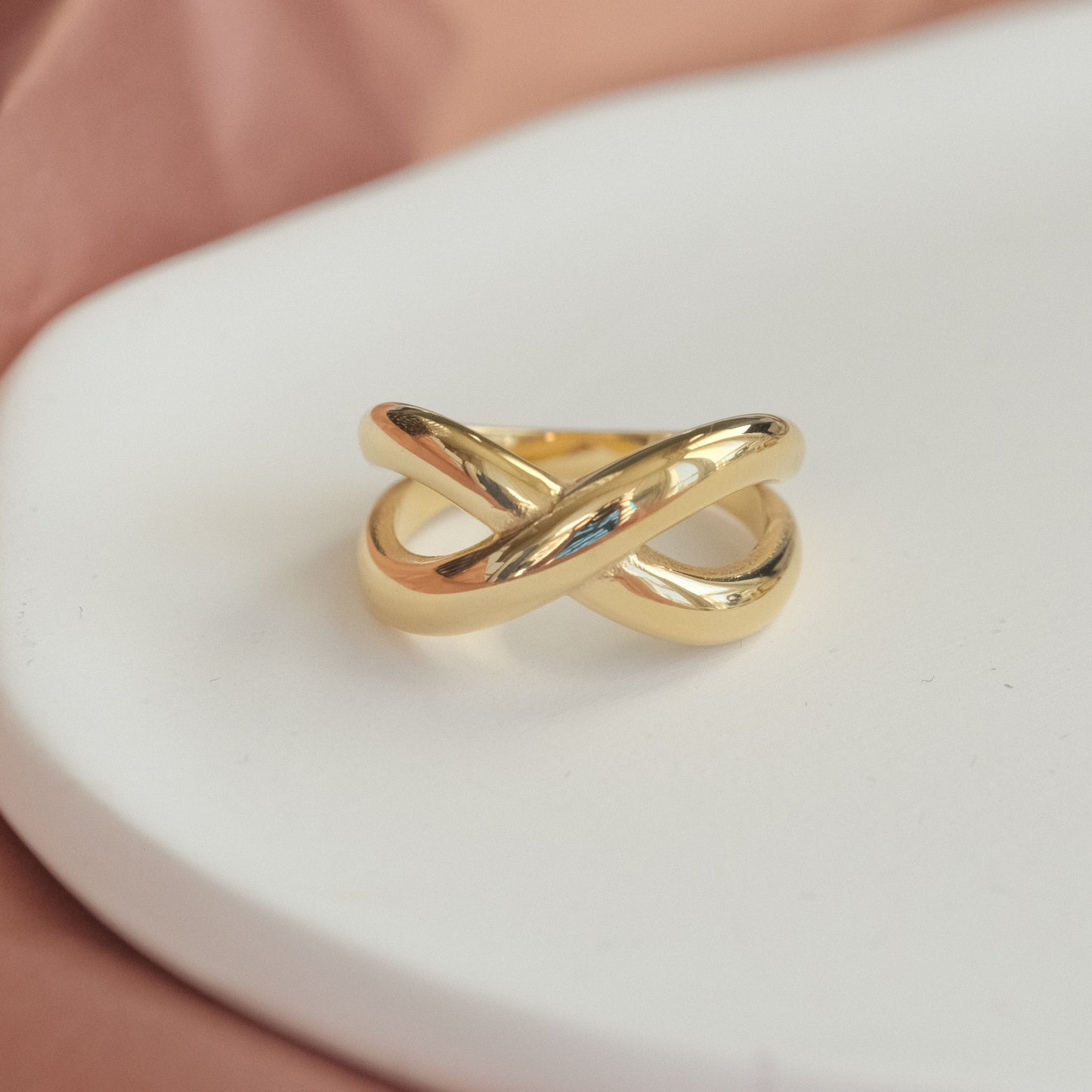 a gold ring sitting on top of a white plate