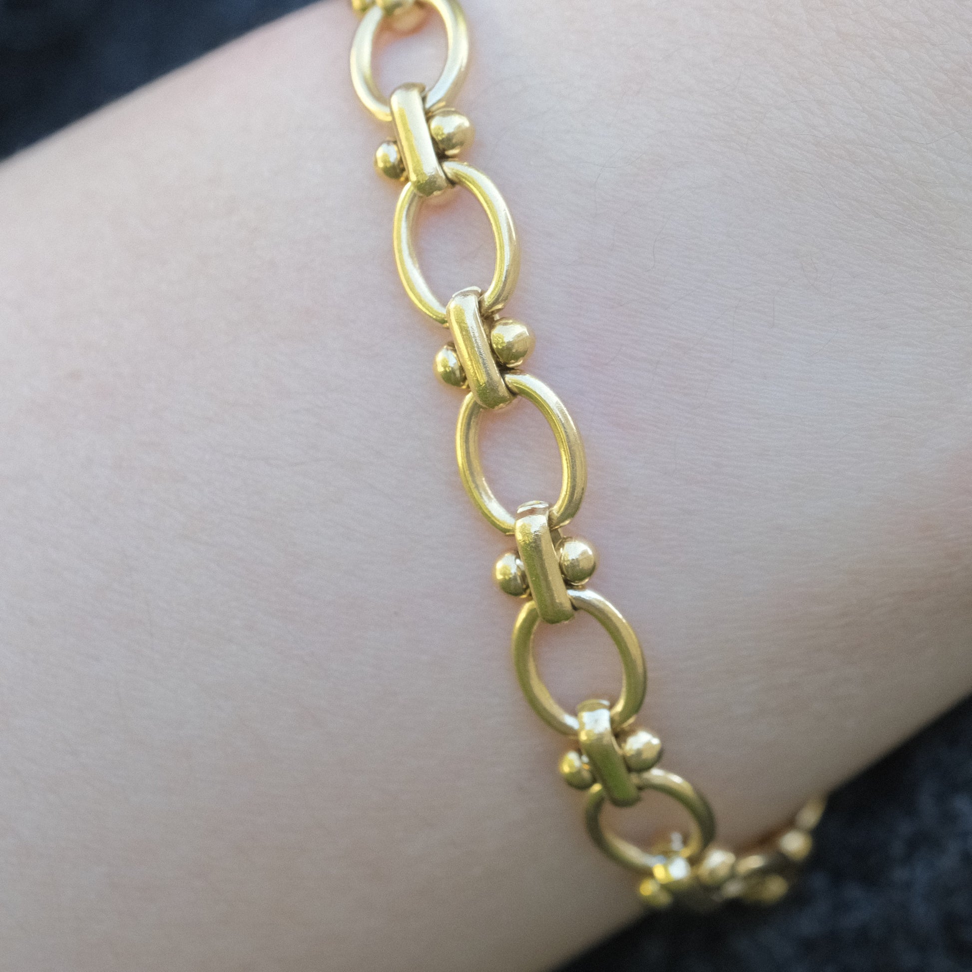 a close up of a person wearing a gold bracelet