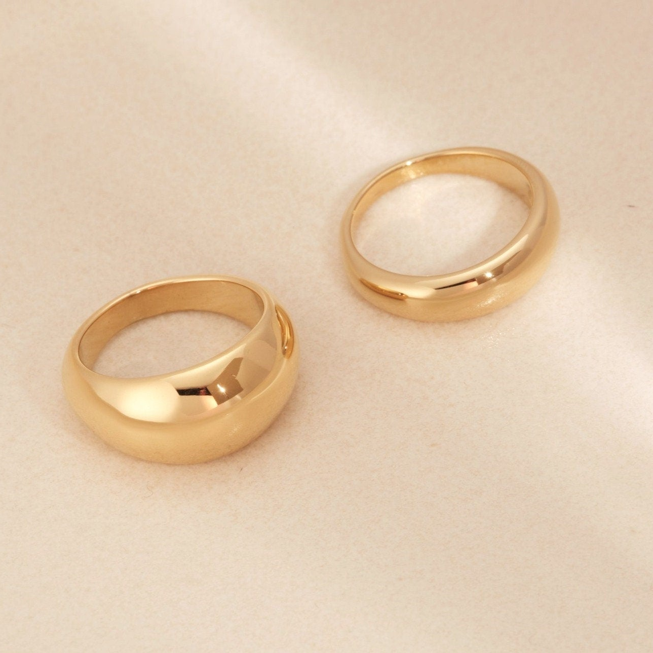 a pair of gold rings sitting on top of a table