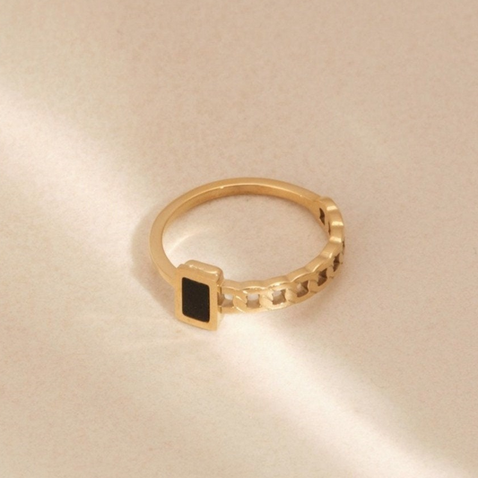 a gold ring with a black stone on it