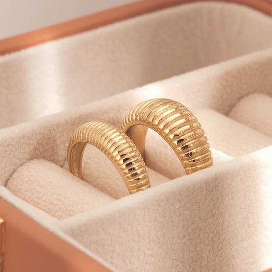 a pair of gold rings sitting inside of a box