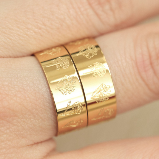 a close up of a person wearing two gold rings