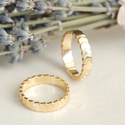 two gold rings sitting on top of a table