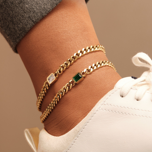 a close up of a person wearing a gold chain bracelet