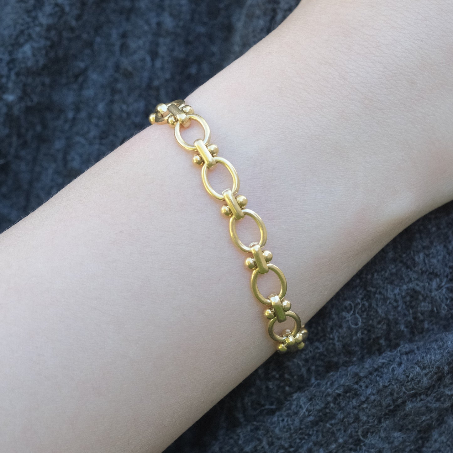 a woman's arm with a gold bracelet on it