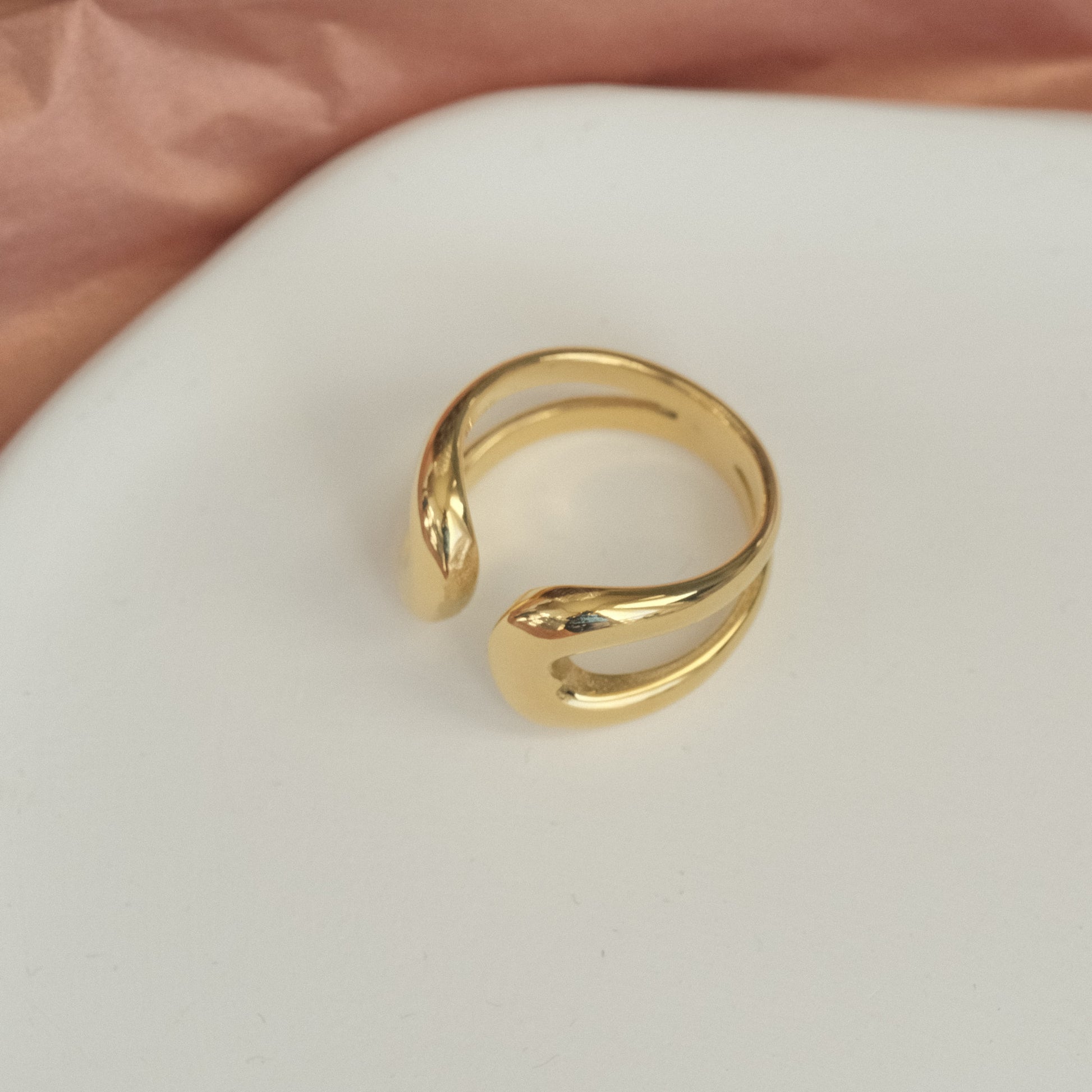 a gold ring sitting on top of a white plate