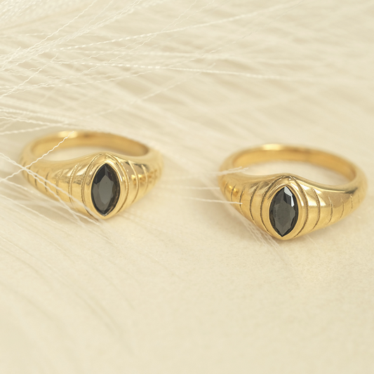 a pair of gold rings with black stones