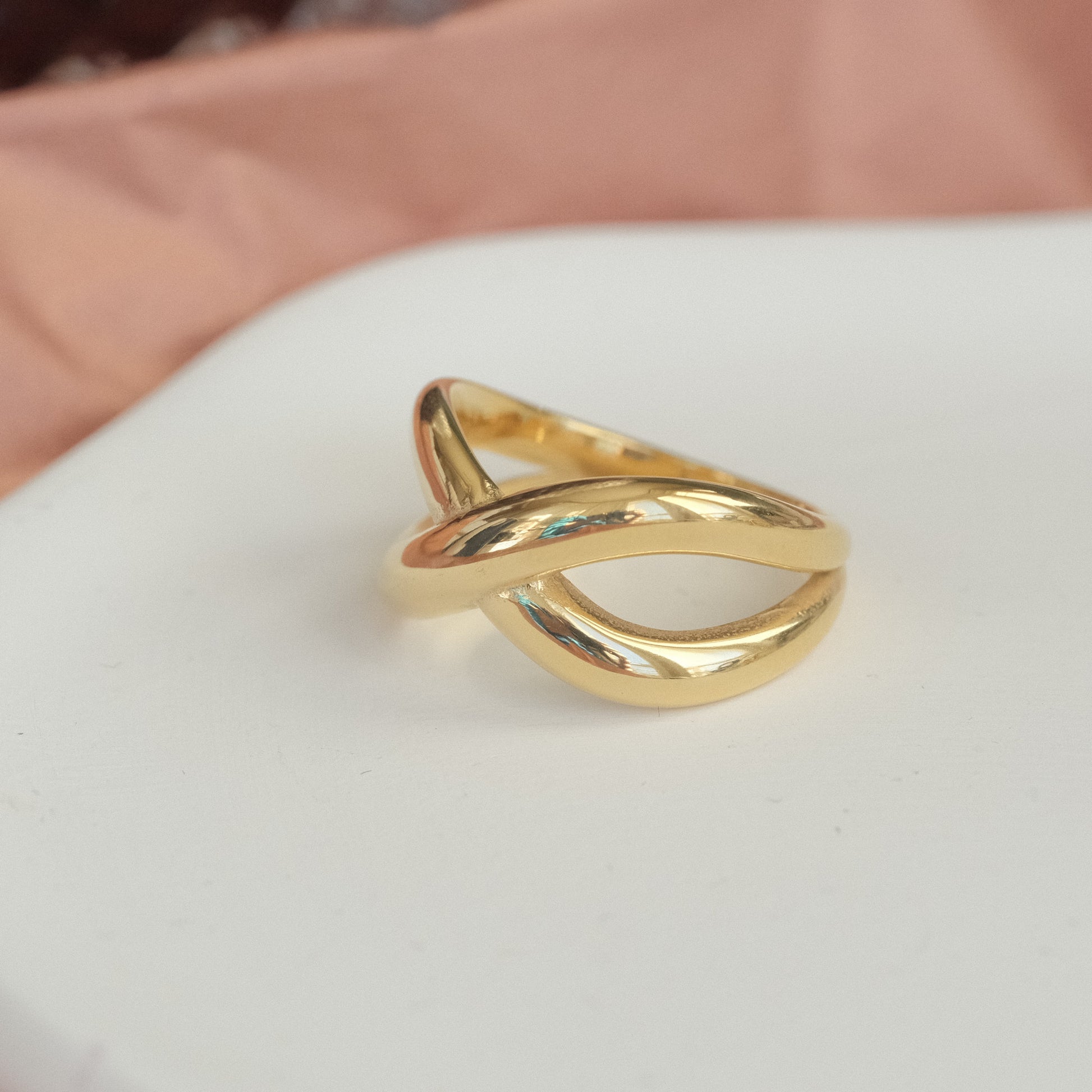 a gold ring sitting on top of a white table