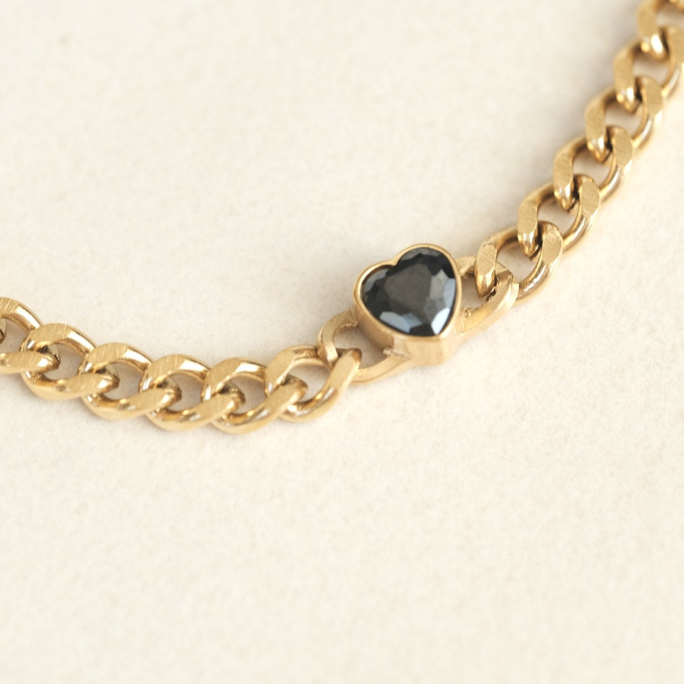 a close up of a chain with a heart on it