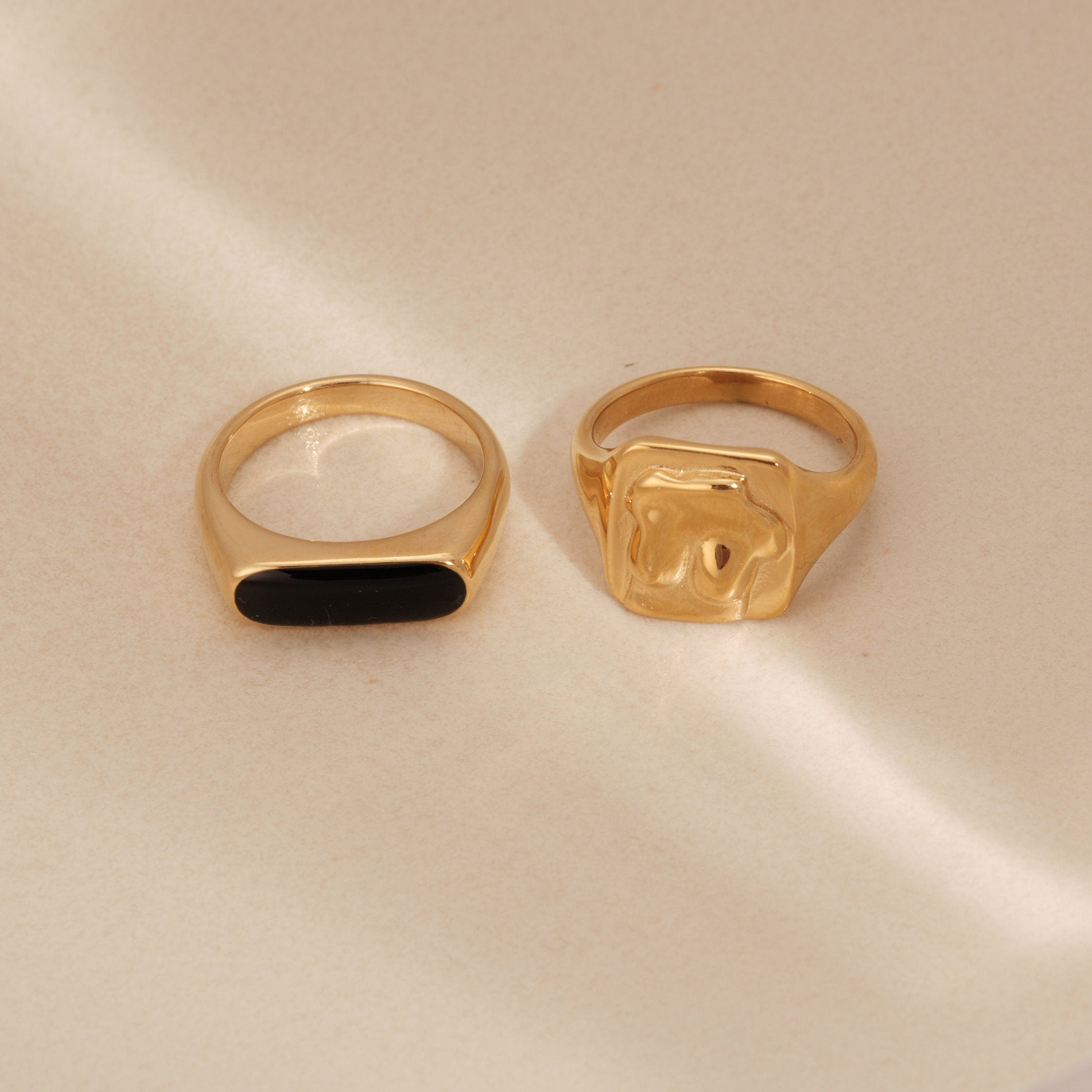 a pair of gold rings sitting on top of a table