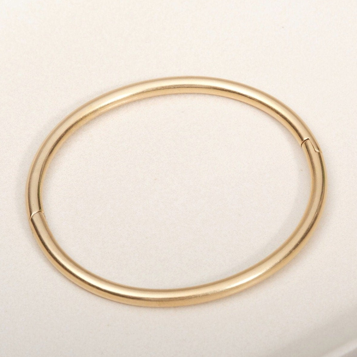 a close up of a gold ring on a white surface