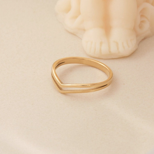 a gold ring sitting on top of a white table