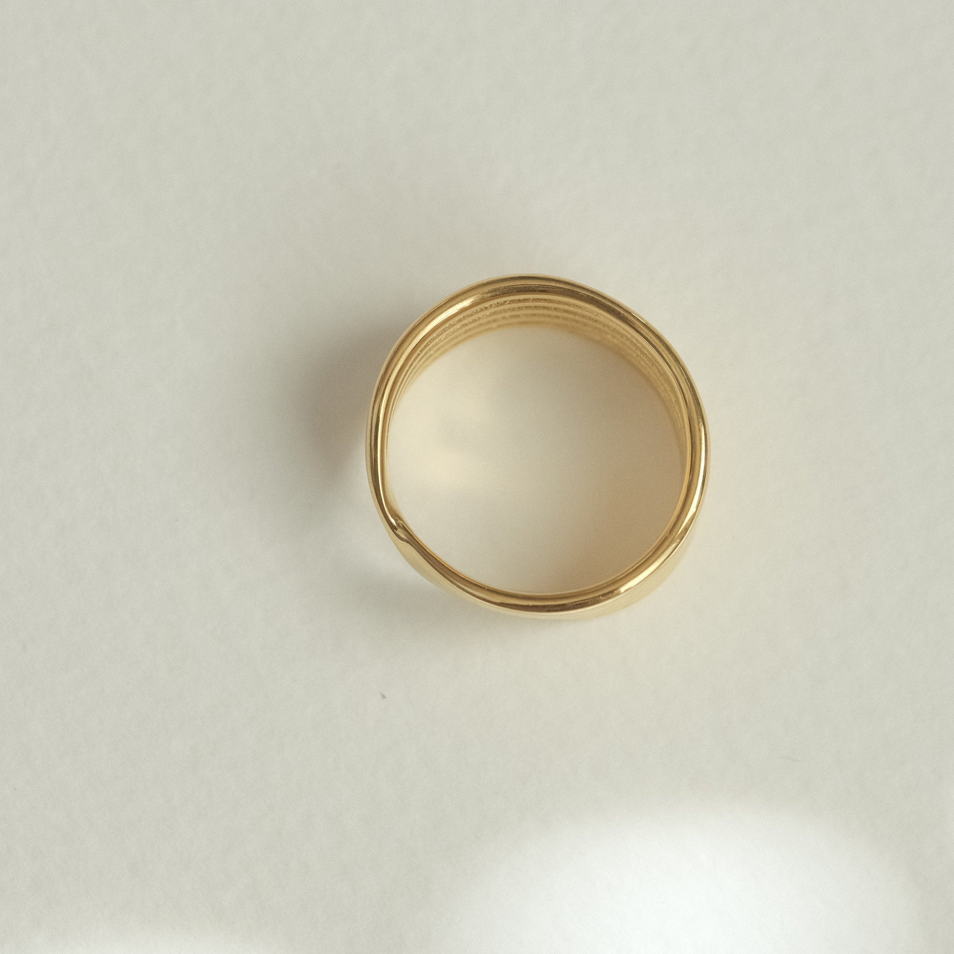 a gold ring on a white surface