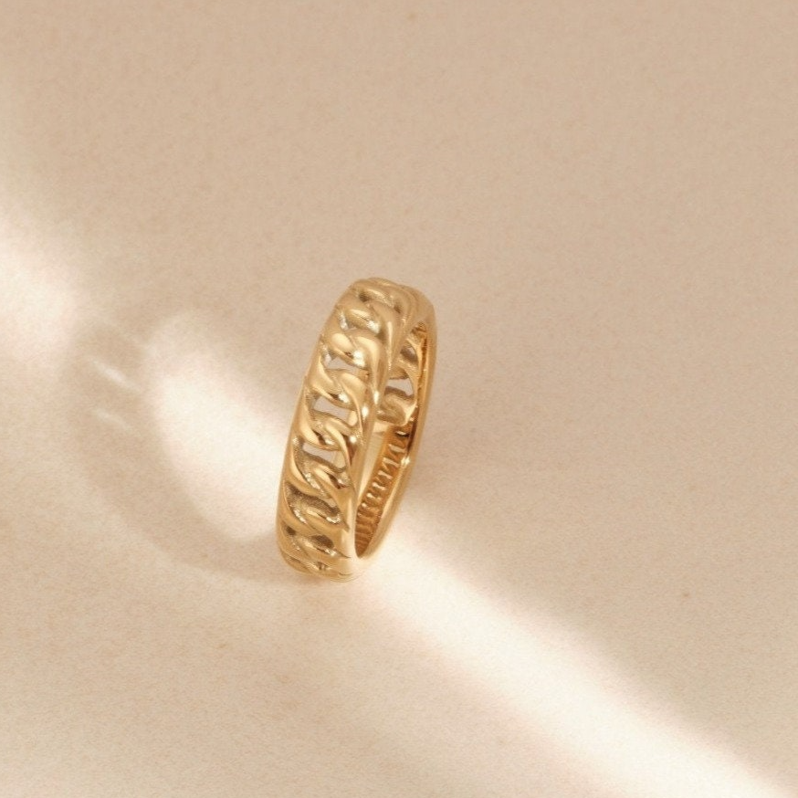 a close up of a gold ring on a white surface