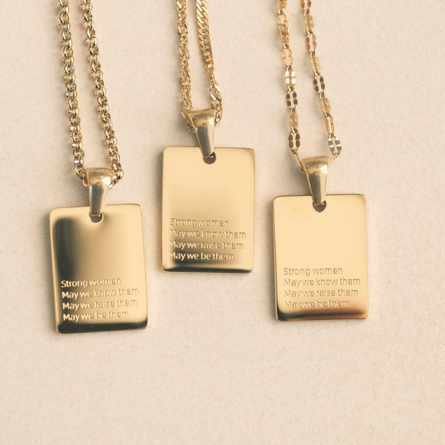 three pendants with words on them sitting on a table