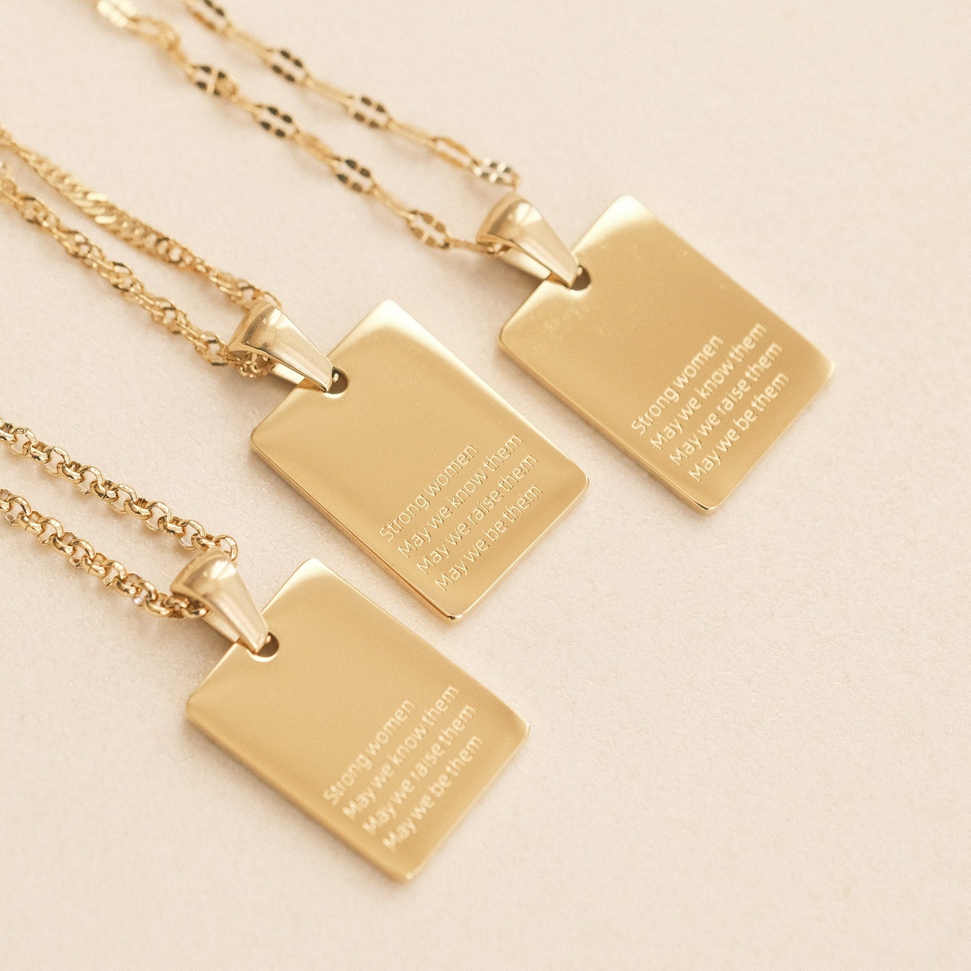 three gold necklaces with a quote on them