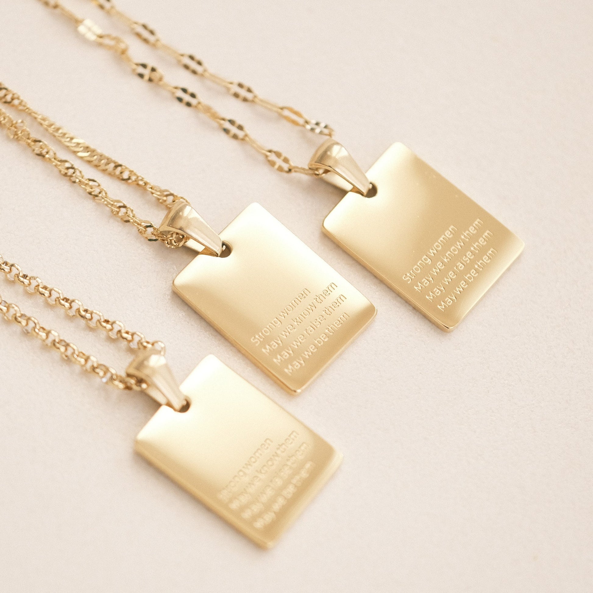 three gold necklaces with a quote on them