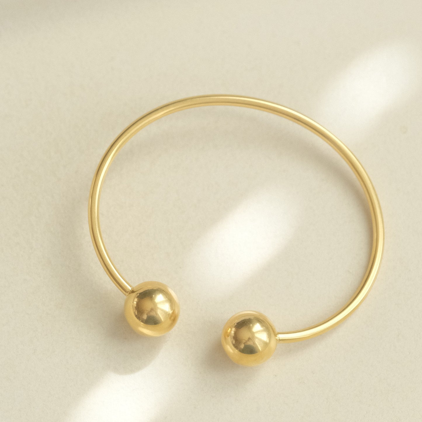 a gold ring with two balls on it