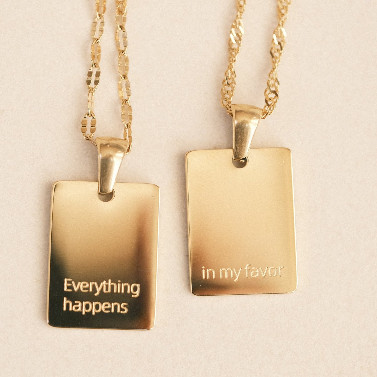 two pendants with words on them on a table